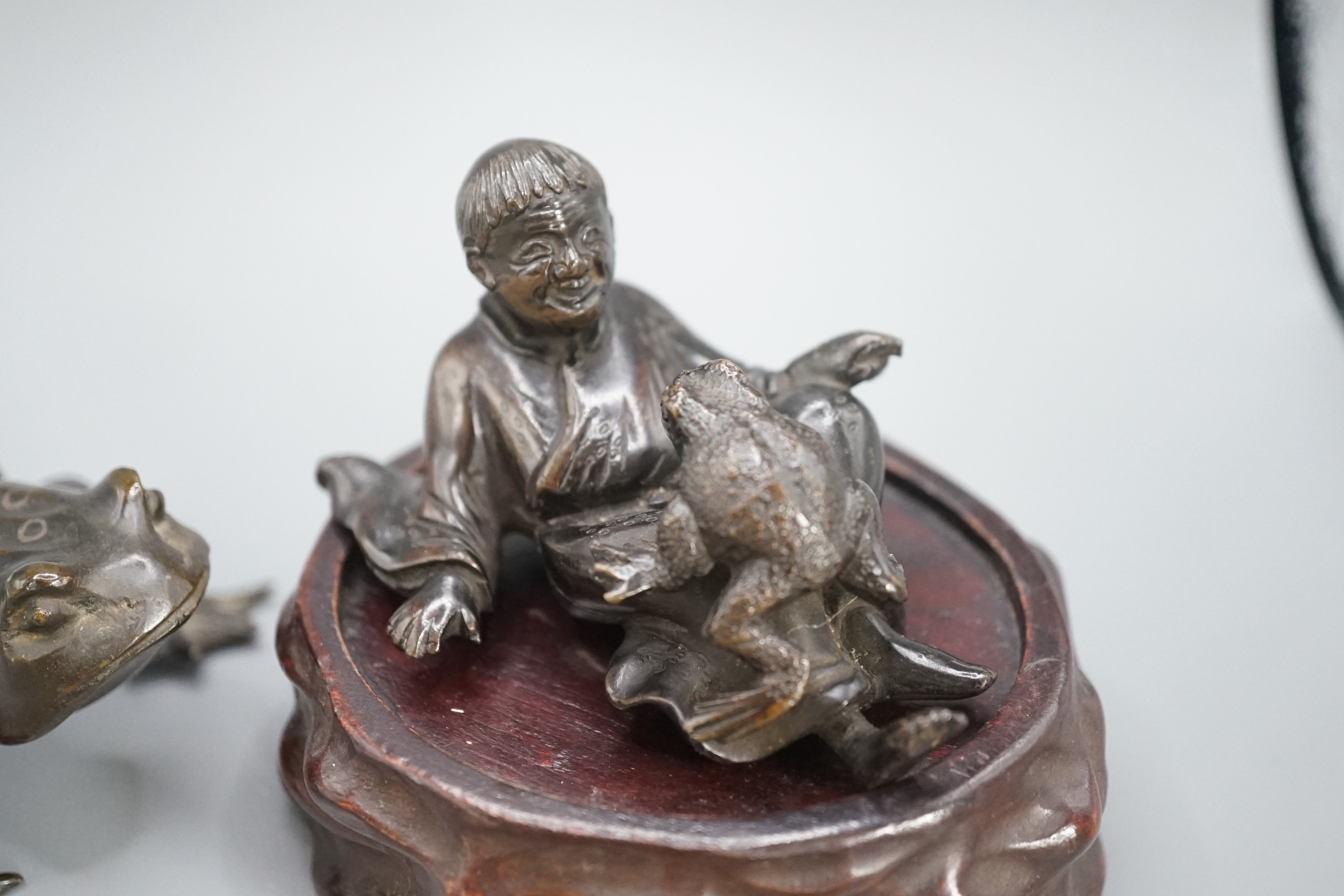 A Chinese bronze group of Liu Hai and a toad, wood stand and a bronze figure of a dog, 9cm
